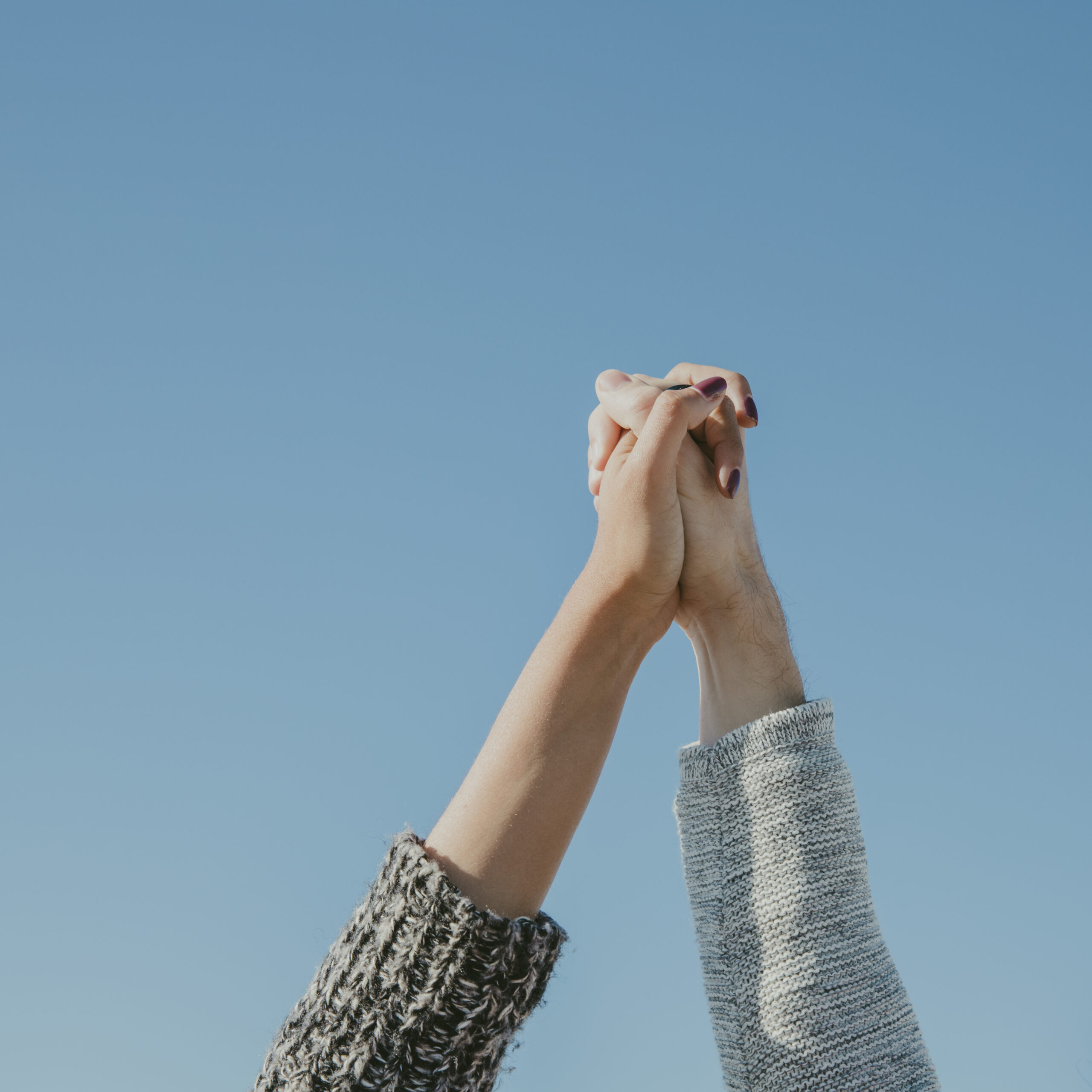 Holding hands front sky